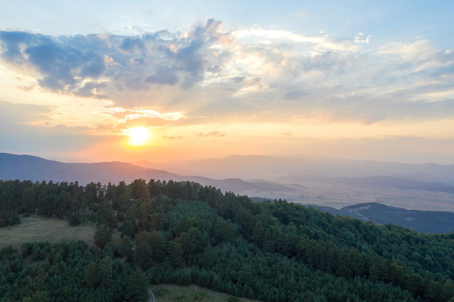 Sunset over forested mountain ridges in Bulgaria
