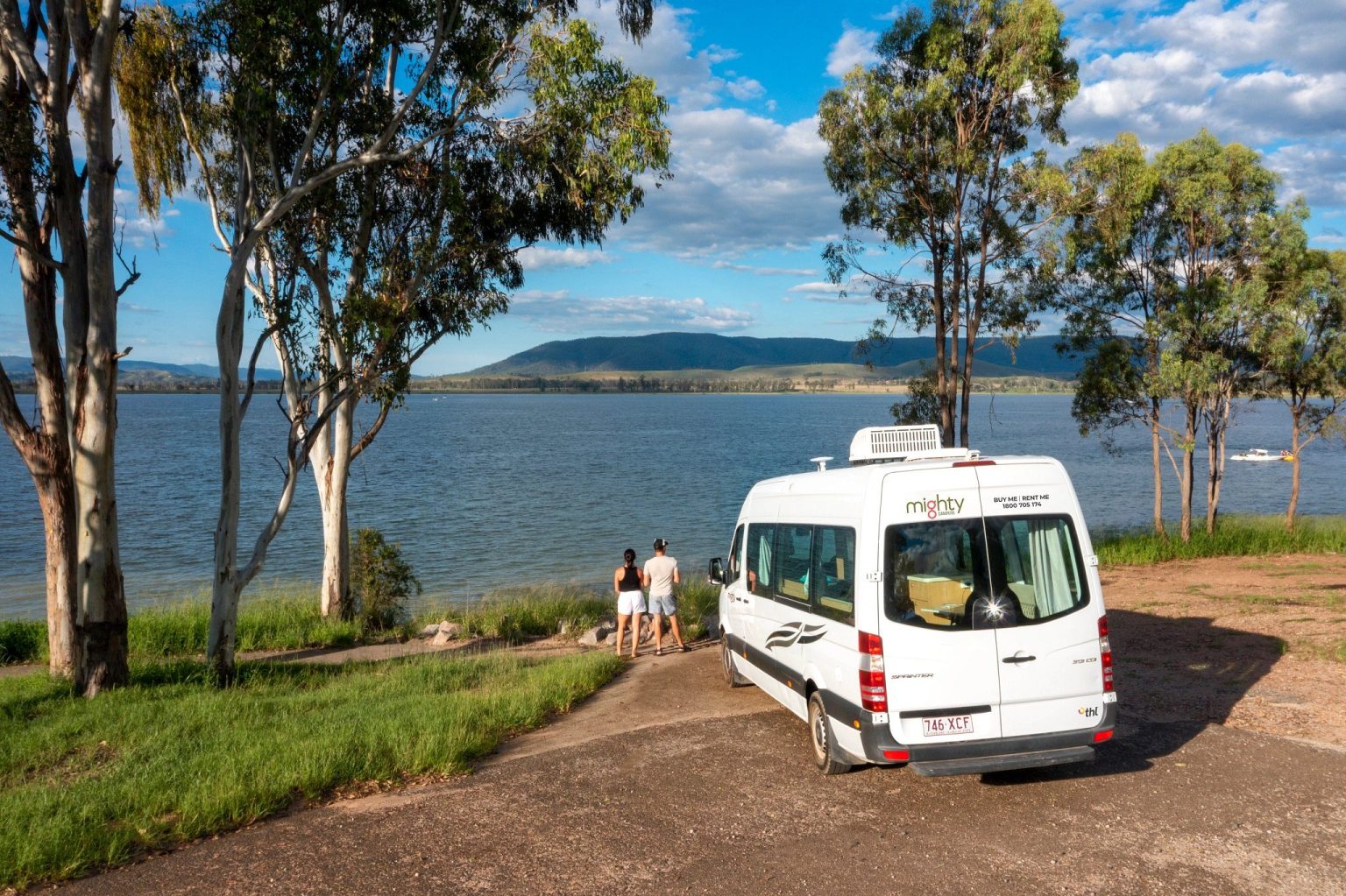 Campervan parked under gum trees beside a lake, Queensland