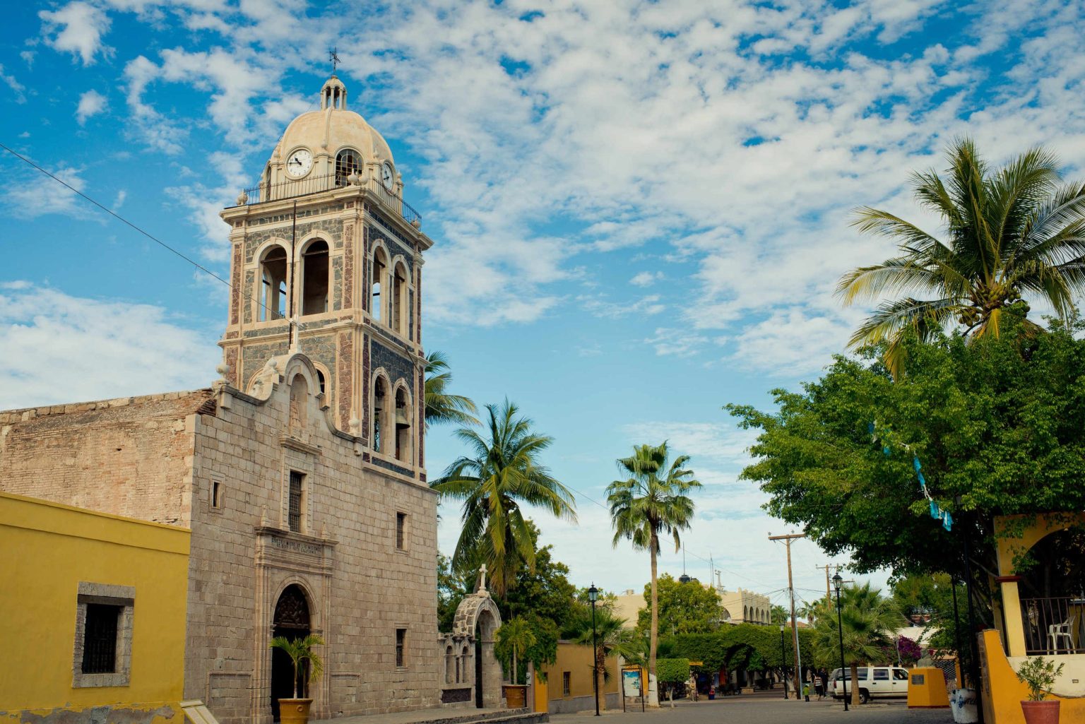 Mission church bell tower and palm trees in Loreto, Baja California Sur