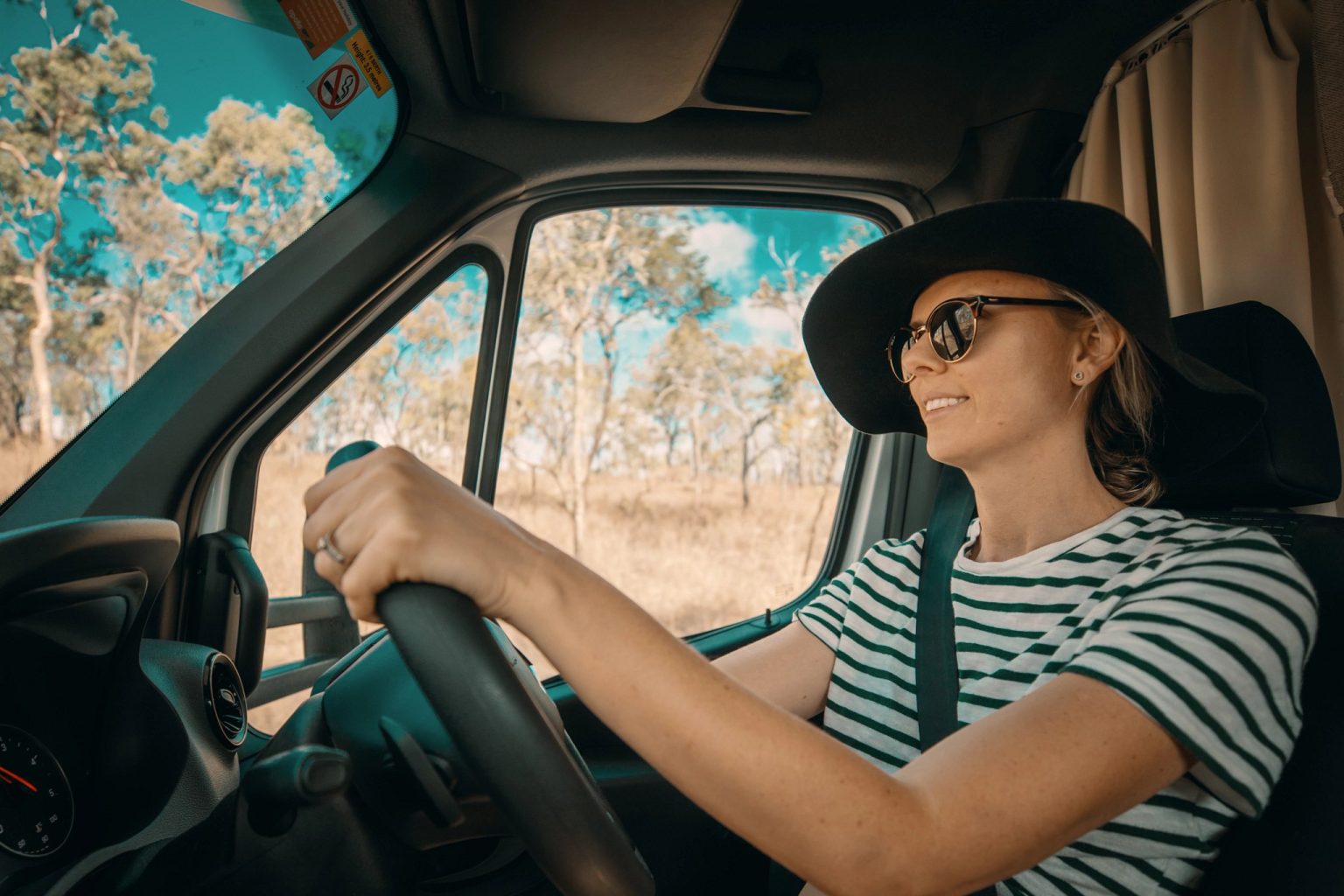 Woman in a sunhat driving a campervan, Cairns, Queensland