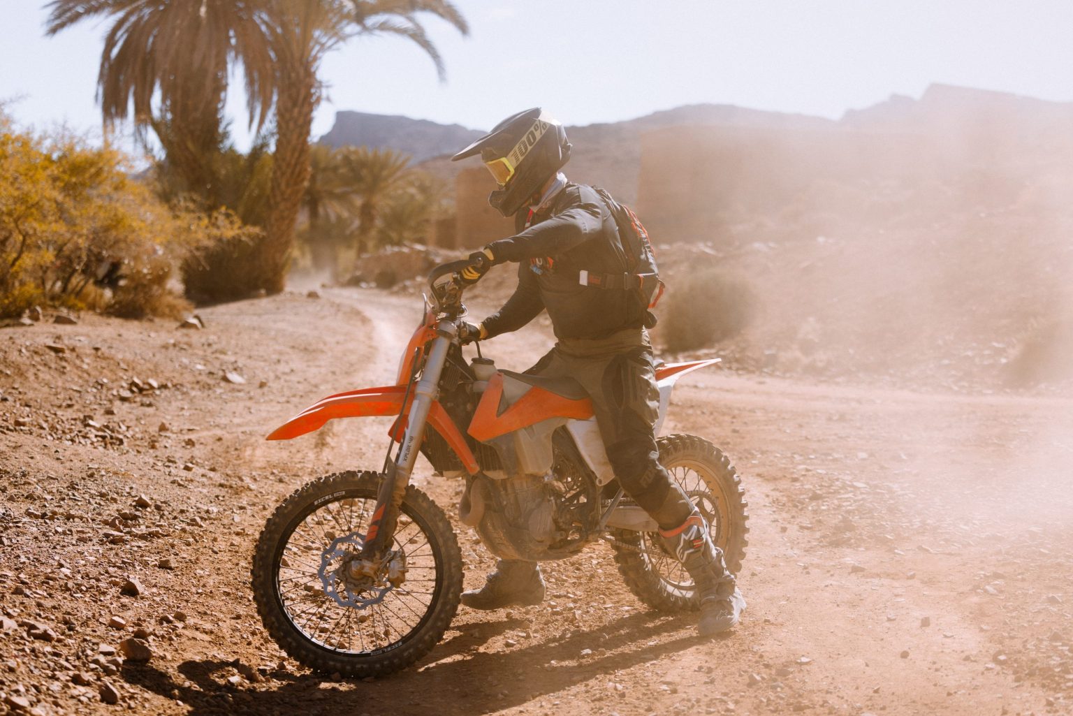 Rider on a dirt bike speeding across a desert piste in Morocco