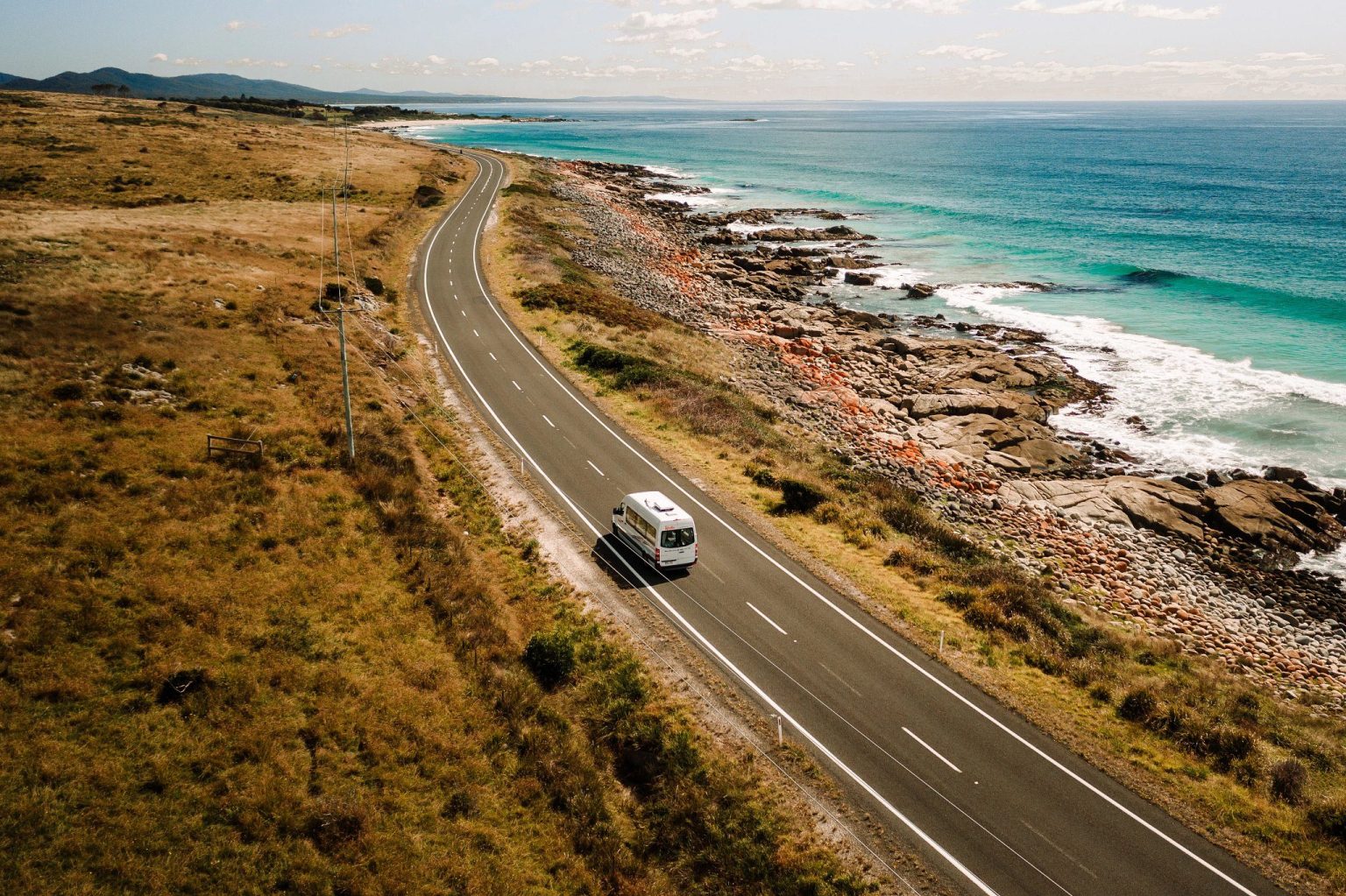 Aerial view of a campervan on a coastal road by the surf, Hobart, Tasmania