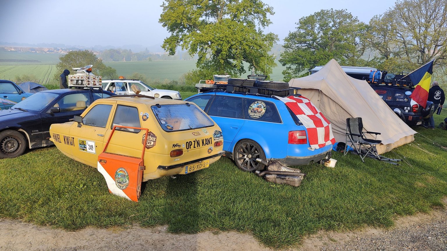 Painted rally cars and tents at a rally campsite
