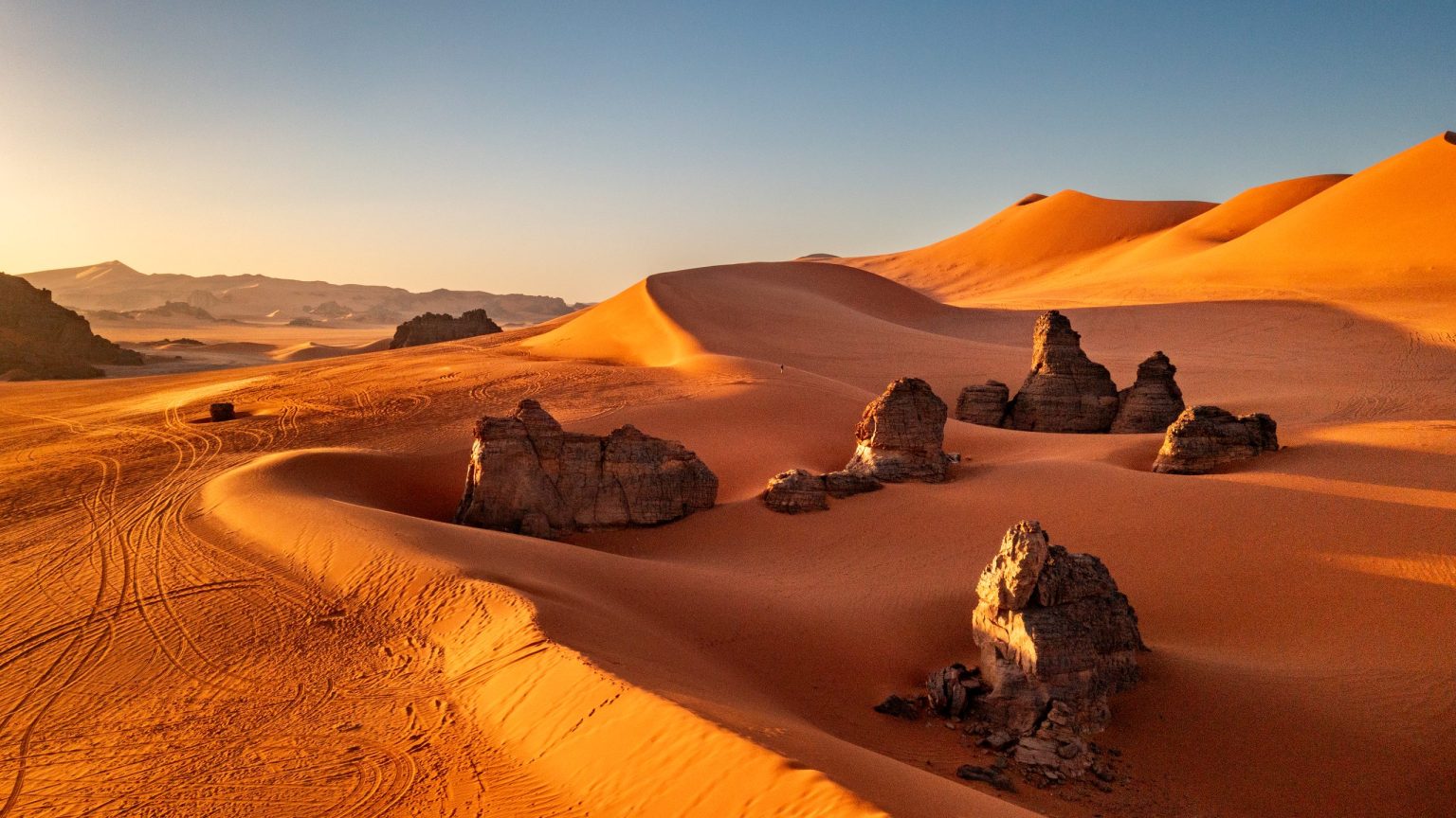 Sahara sand dunes and rock outcrops at sunset, Morocco