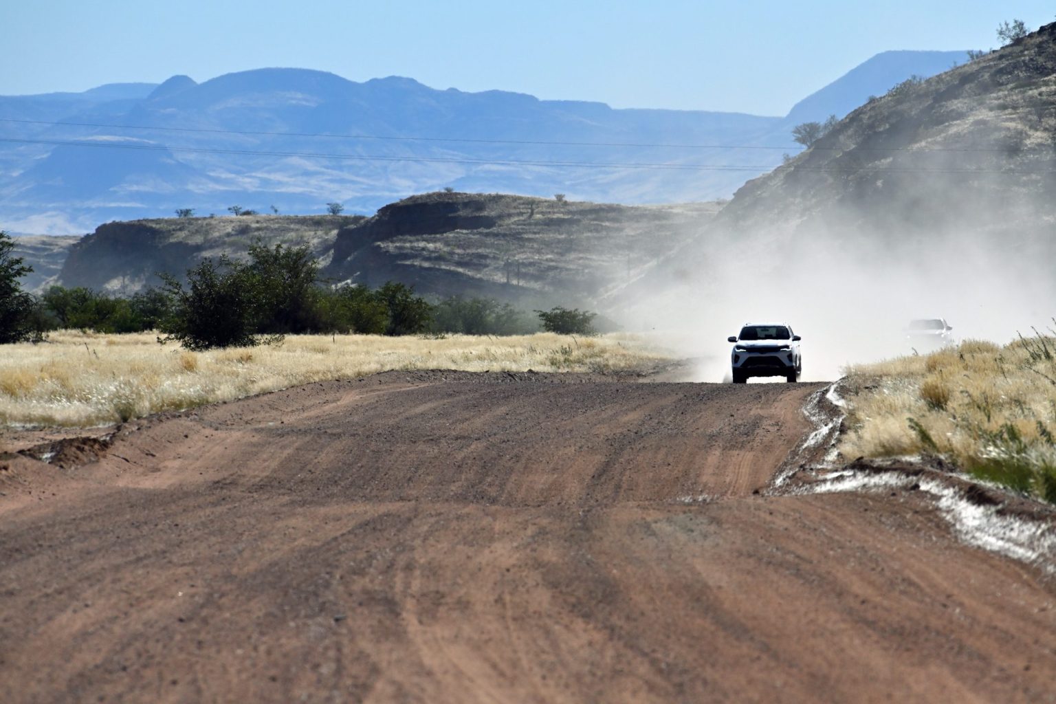 4x4 raising dust on a gravel road through the Namibian desert