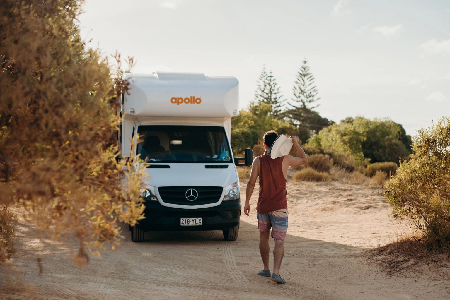 Man walking from a motorhome parked in coastal scrub, Perth, Western Australia