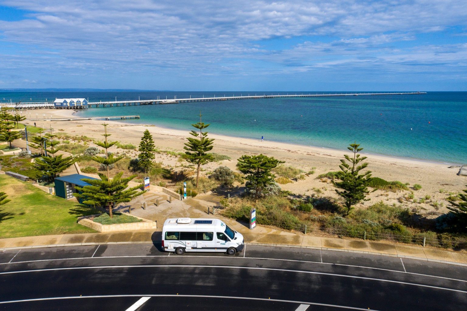 Campervan parked above a beach with a long jetty, Margaret River, Western Australia