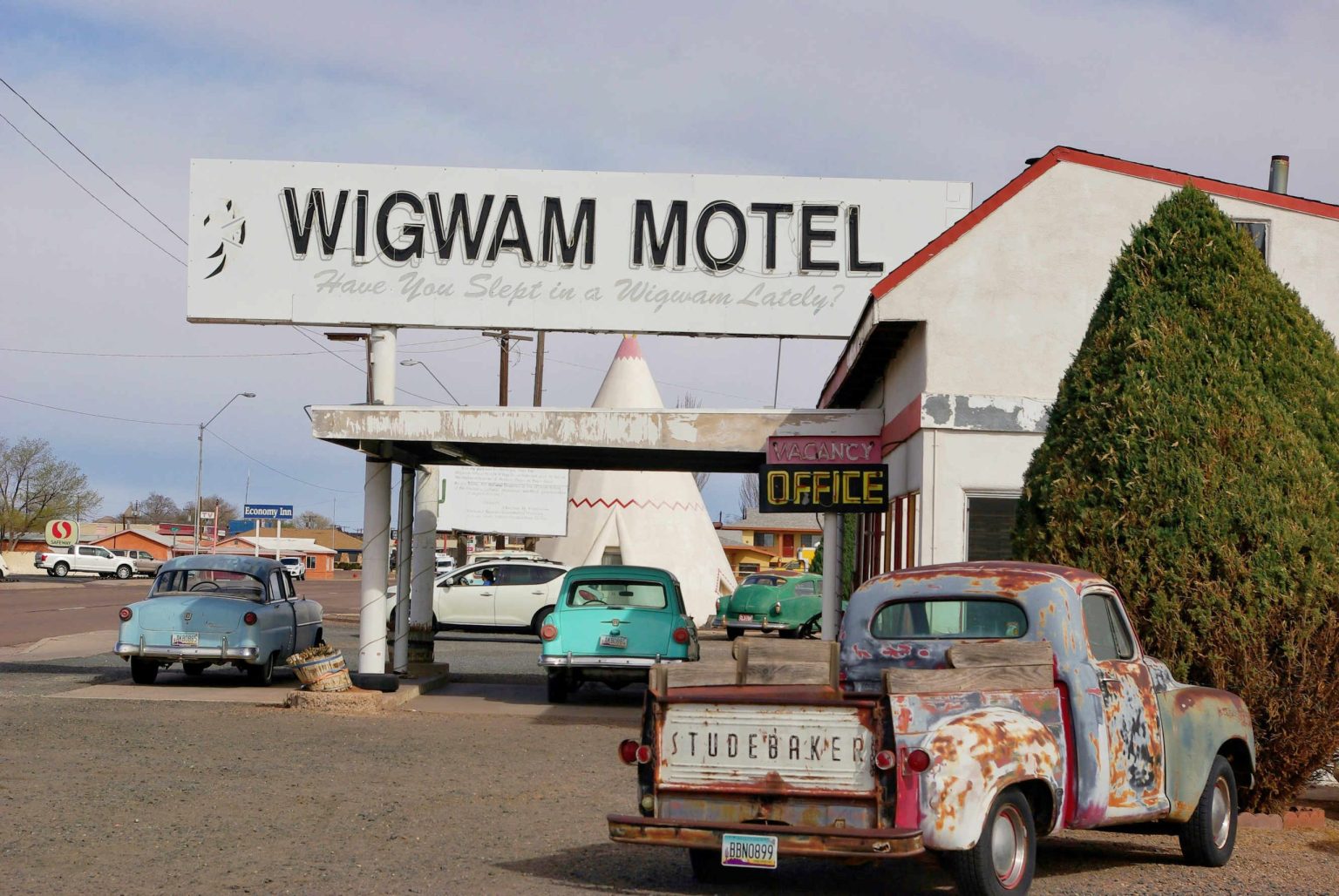 Wigwam Motel sign and vintage trucks on Route 66 in Holbrook, Arizona