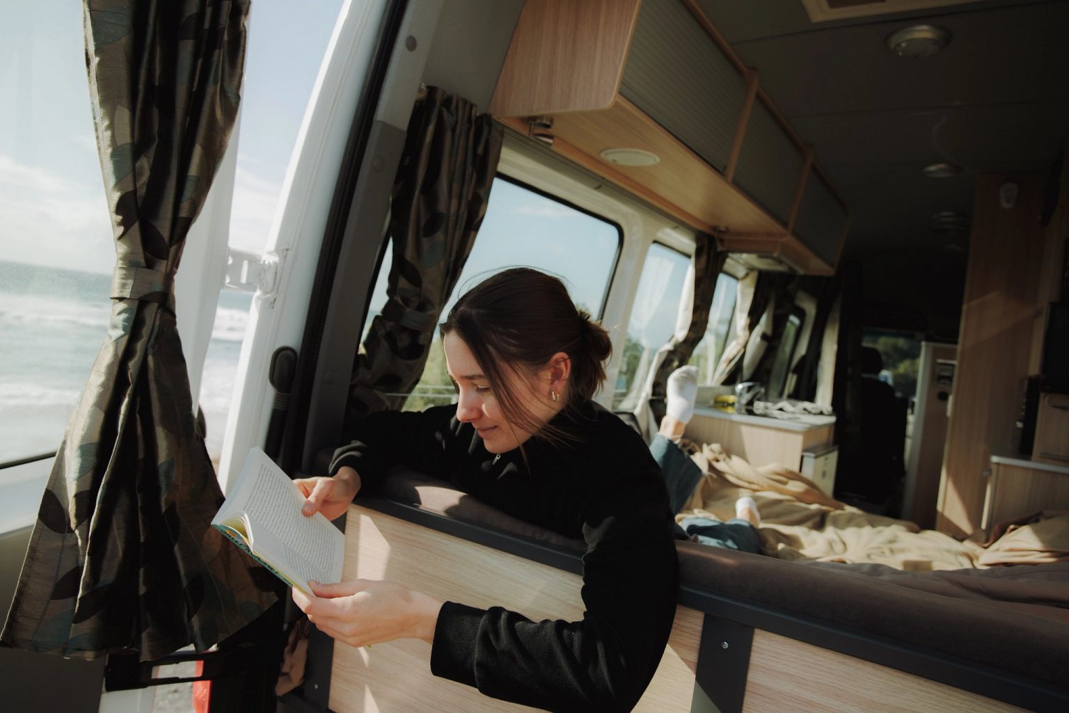 Woman reading a map inside a campervan, Catlins, New Zealand's South Island