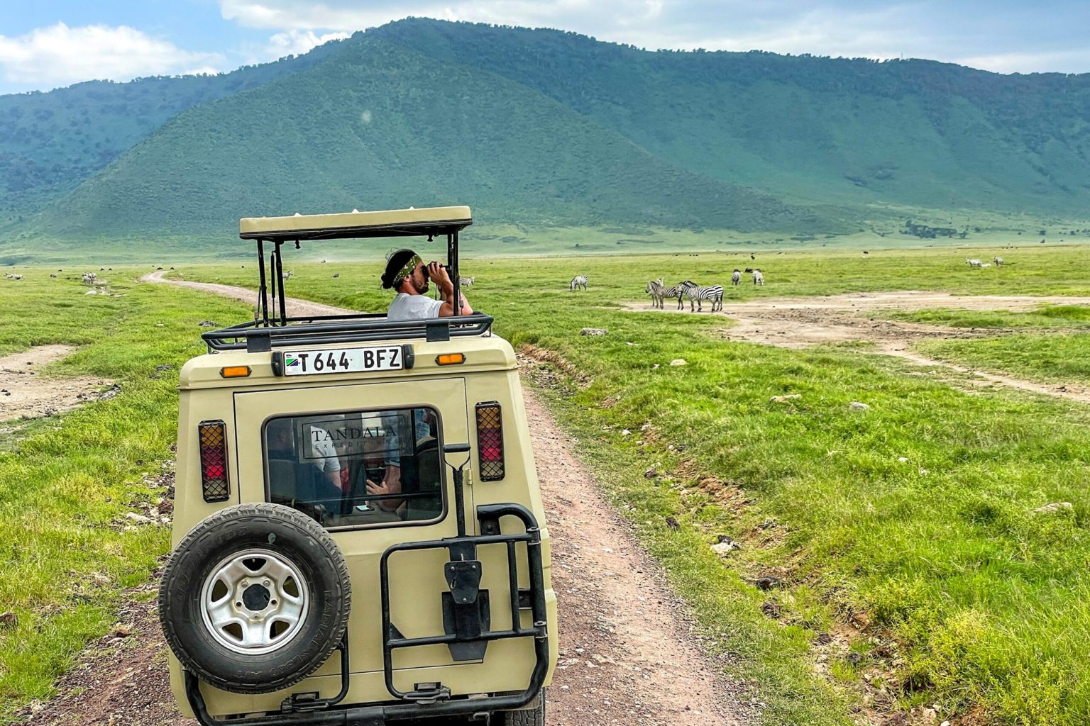 Safari jeep on a dirt track across the Ngorongoro Crater floor, Tanzania