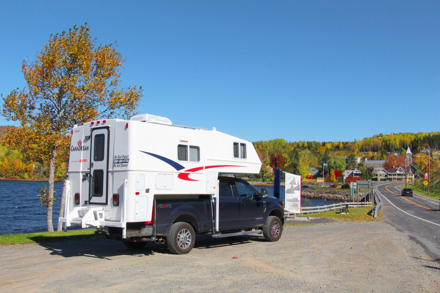 Truck camper parked by a lake and small town, Nova Scotia, Canada